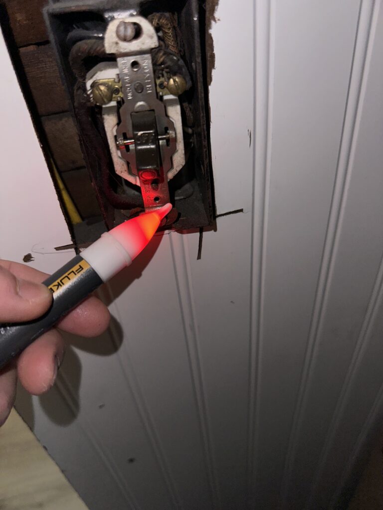 Electrician troubleshooting an overheated light switch during electrical repair by Del Haven Electric
