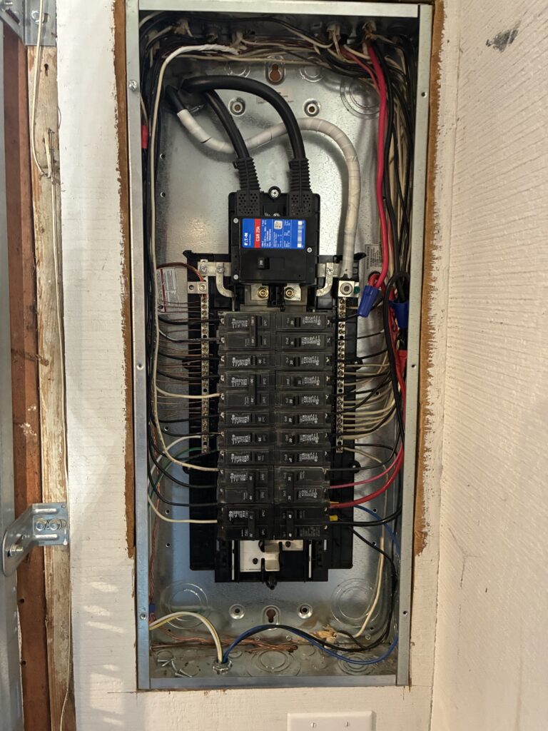 Open commercial electrical panel with breakers installed by Del Haven Electric