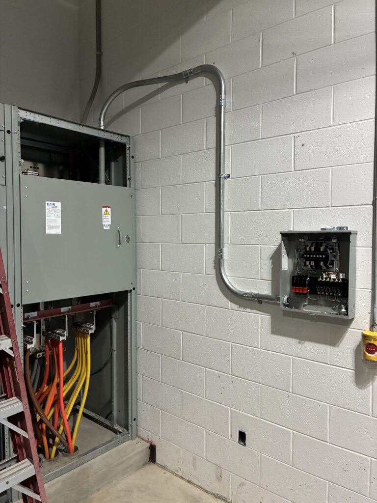 Commercial electrical panel and disconnect box installed on cinder block wall in Federal Way