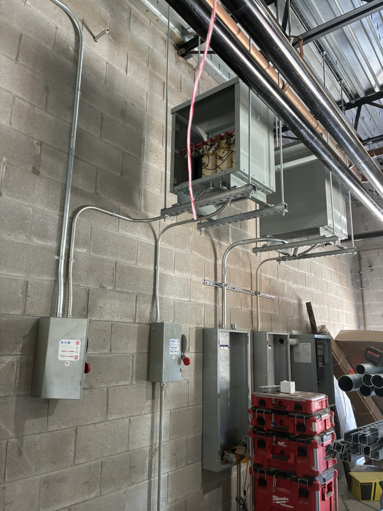 Commercial electrical panels and disconnect boxes mounted on cinder block wall