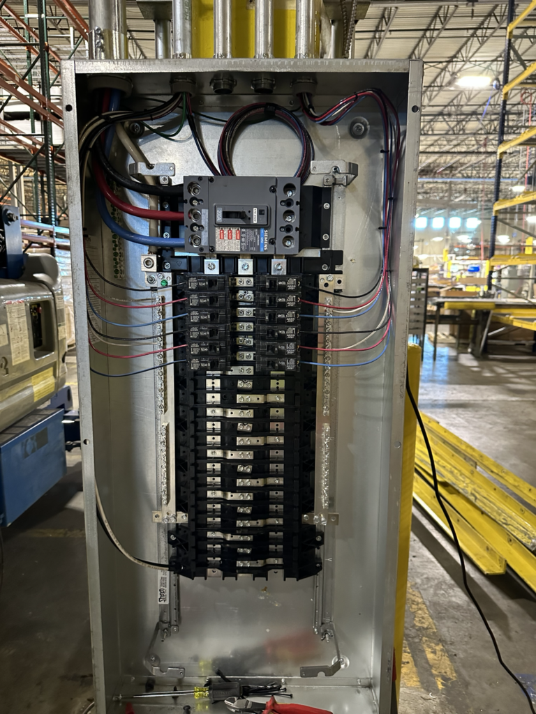 Distribution panel with breakers installed in manufacturing facility