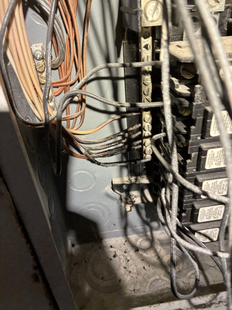 Heat-damaged conductors and terminations inside electrical panel