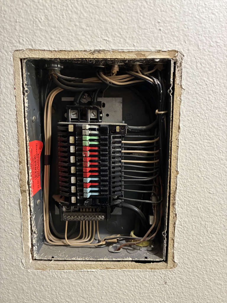 Inside view of outdated electrical panel before removal